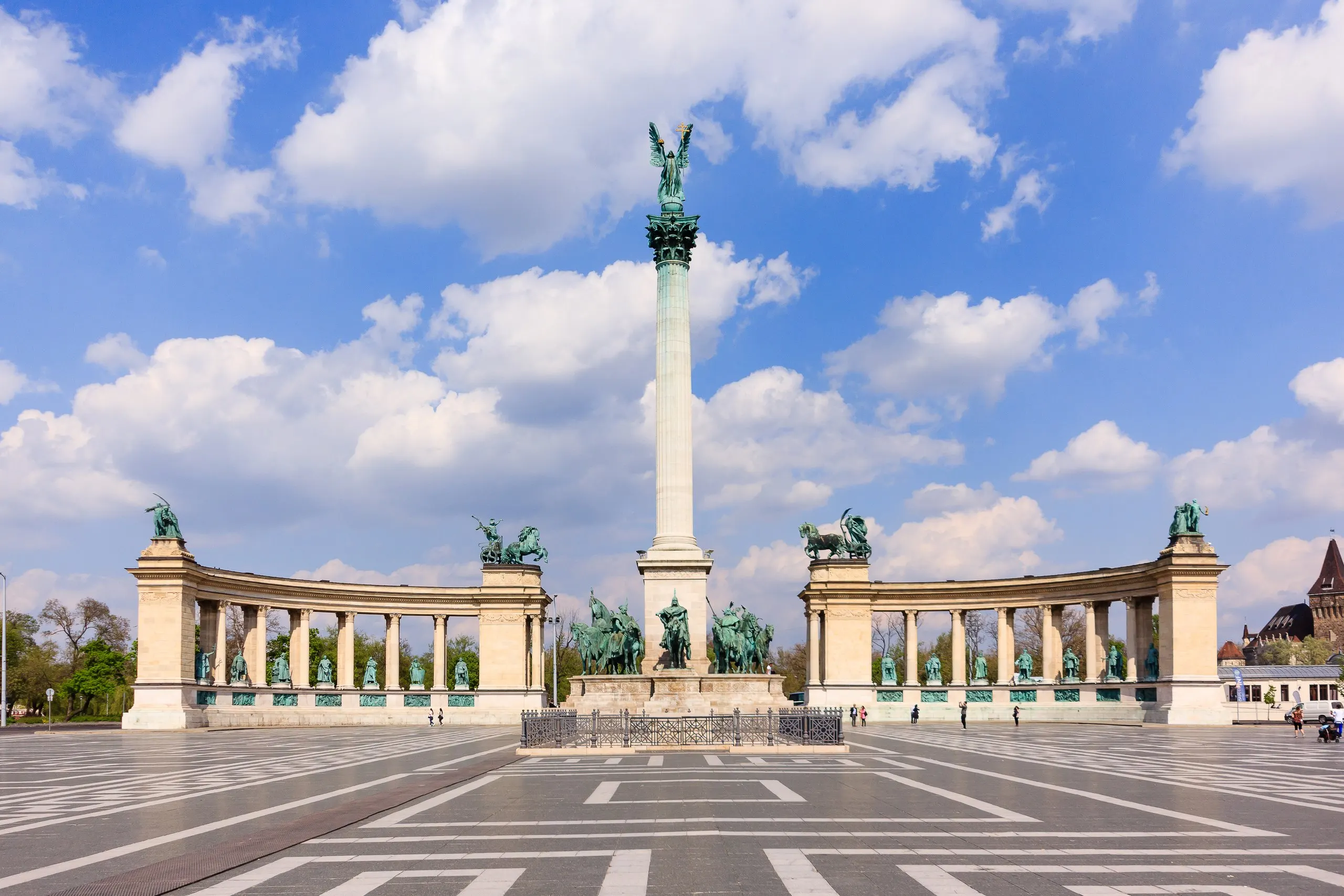 Heroes' Square in Budapest, the Millennium Monument's column and curved colonnade under a bright sky.