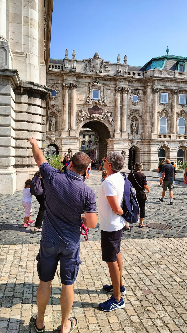 Our guide pointing up at the Habsburg gate of Buda Castle while the group follows his hand
